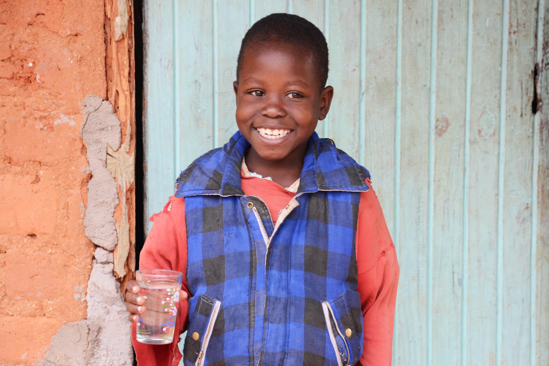 child holding a glass of clean water